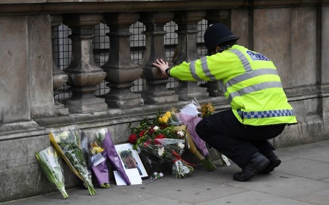 A police officer lays flowers on Whitehall around a photograph of police officer Keith Palmer who was killed in the March 22 terror attack in Westminster, in Westminster near the Houses of the Parliament in central London on March 23, 2017. (AFP/ Justin TALLIS) A police officer lays flowers on Whitehall around a photograph of police officer Keith Palmer who was killed in the March 22 terror attack in Westminster, in Westminster near the Houses of the Parliament in central London on March 23, 2017. (AFP/ Justin TALLIS)