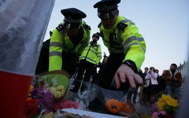 Police officers lay flowers in honor of the victims of the March 22 terror attack on the Westminster Bridge by the Houses of Parliament in central London on March 23, 2017. (AFP/Daniel Leal Olivas) Police officers lay flowers in honor of the victims of the March 22 terror attack on the Westminster Bridge by the Houses of Parliament in central London on March 23, 2017. (AFP/Daniel Leal Olivas)
