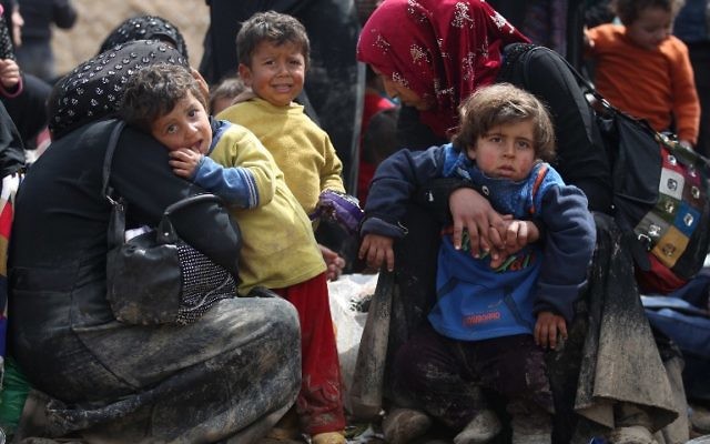 Displaced Iraqis from Mosul rest as they walk towards refugee camps on March 24, 2017, after fleeing their city during the government forces ongoing offensive to retake the city from Islamic State (IS) group fighters. (AFP PHOTO / AHMAD AL-RUBAYE)