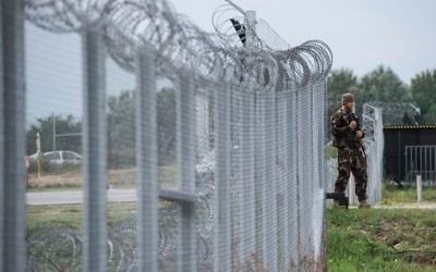 In this Sept. 21, 2016 file photo a Hungarian soldier patrols at the transit zone at Hungary's southern border with Serbia near Tompa, 169 km southeast of Budapest, Hungary. (Sandor Ujvari/MTI via AP, file)