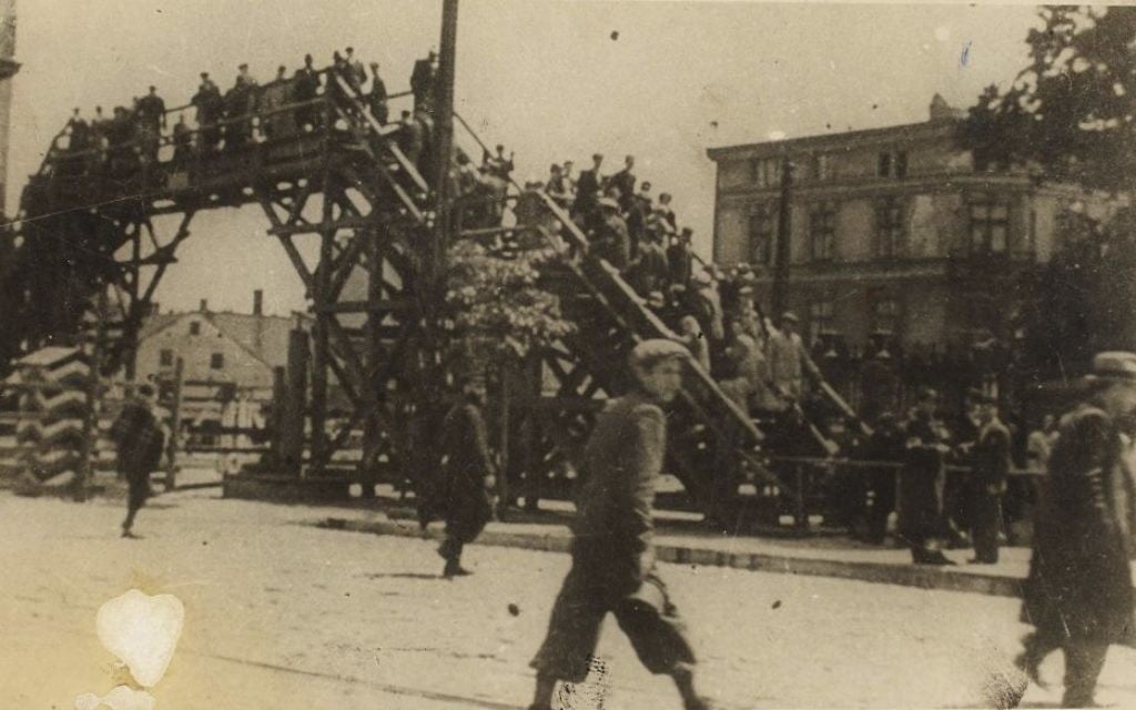 A boy walking in front of the bridge crossing. (Henryk Ross/Art Gallery of Ontario, gift from the Archive of Modern Conflict/Courtesy Museum of Fine Arts)