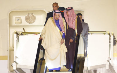 Saudi King Salman, left, rides on a special escalator to disembark from his plane upon his arrival at Haneda International Airport in Tokyo, Sunday, March 12, 2017. Salman arrived in Japan as part of a month-long Asian tour. (AP Photo/Shizuo Kambayashi)