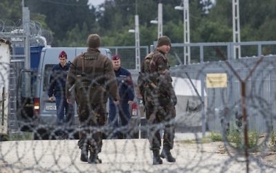 In this Sept. 21, 2016 file photo Hungarian soldiers, front, and police officers patrol at the transit zone at Hungary's southern border with Serbia near Tompa, 169 km southeast of Budapest, Hungary.  (Sandor Ujvari/MTI via AP, file)