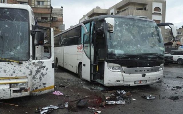 This photo released by the Syrian official news agency SANA shows blood soaked streets and several damaged buses in a parking lot at the site of an attack by twin explosions in Damascus, Syria, Saturday, March 11, 2017. (SANA via AP) This photo released by the Syrian official news agency SANA shows blood soaked streets and several damaged buses in a parking lot at the site of an attack by twin explosions in Damascus, Syria, Saturday, March 11, 2017. (SANA via AP)