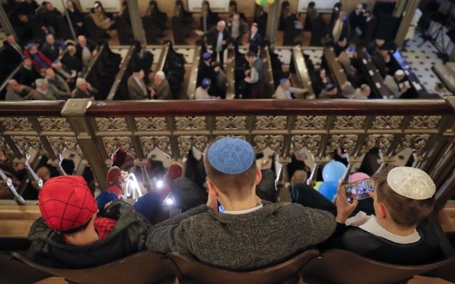 In this March 11, 2017 picture, children, one wearing a Spiderman costume sit before Purim celebrations at the Coral Temple synagogue in Bucharest, Romania. Children put on fancy costume dress joining dozens of believers from Romania's Jewish community who attended a Purim service to celebrate the Jews' salvation from genocide in ancient Persia, as recounted in the Book of Esther.(AP Photo/Vadim Ghirda)