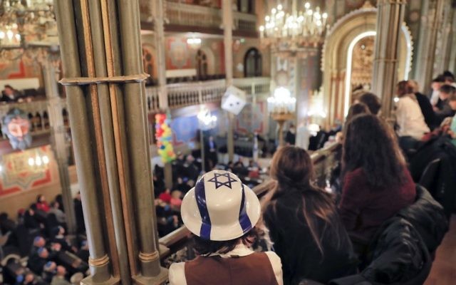 In this March 11, 2017, picture, members of Romania's Jewish community attend Purim celebrations at the Coral Temple synagogue in Bucharest, Romania. (AP Photo/Vadim Ghirda)