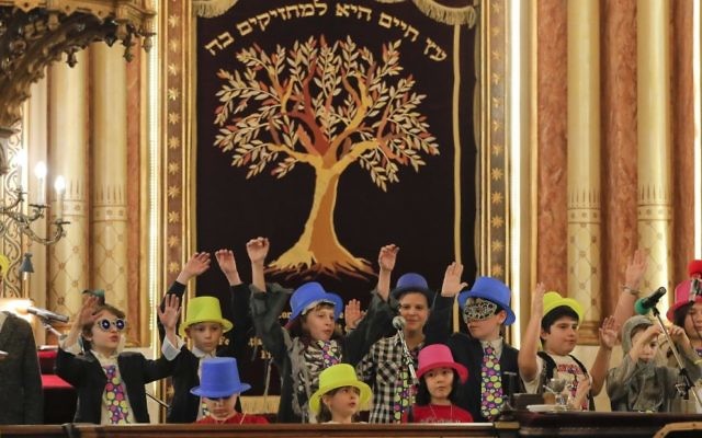 In this March 11, 2017 picture, children sing during Purim celebrations at the Coral Temple synagogue in Bucharest, Romania. Children put on fancy costume dress joining dozens of believers from Romania's Jewish community who attended a Purim service to celebrate the Jews' salvation from genocide in ancient Persia, as recounted in the Book of Esther.(AP Photo/Vadim Ghirda)