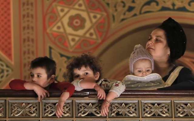In this March 11, 2017 picture, children attend Purim celebrations at the Coral Temple synagogue in Bucharest, Romania. Children put on fancy costume dress joining dozens of believers from Romania's Jewish community who attended a Purim service to celebrate the Jews' salvation from genocide in ancient Persia, as recounted in the Book of Esther.(AP Photo/Vadim Ghirda)