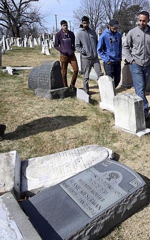 In this Monday, Feb. 27, 2017 file photo, volunteers from the Ahmadiyya Muslim Community survey damaged headstones at Mount Carmel Cemetery in Philadelphia. (AP/Jacqueline Larma)