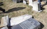 In this Monday, Feb. 27, 2017 file photo, volunteers from the Ahmadiyya Muslim Community survey damaged headstones at Mount Carmel Cemetery in Philadelphia. (AP/Jacqueline Larma)