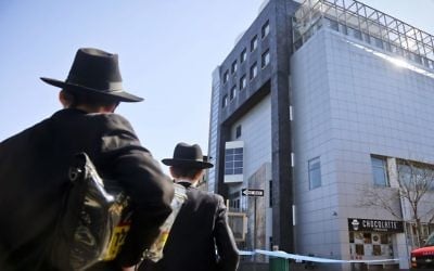 In this Thursday March 9, 2017 file photo, two young men who left a nearby synagogue watch police activity outside the Jewish Children's Museum following a bomb threat in Brooklyn borough of New York. (AP Photo/Bebeto Matthews)