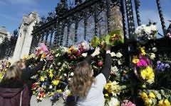 People place flowers outside Britain's parliament in London, Saturday March 25, 2017, for the victims of the Westminster terror attack. (AP Photo/Kirsty Wigglesworth)