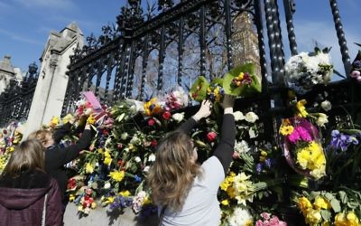 People place flowers outside Britain's parliament in London, Saturday March 25, 2017, for the victims of the Westminster terror attack. (AP Photo/Kirsty Wigglesworth)