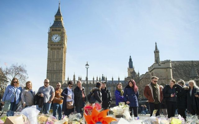 People look at floral tributes in Parliament Square, London, Sunday, March 26, 2017, laid out for the victims of the Westminster attack on Wednesday. (Dominic Lipinski/PA via AP) People look at floral tributes in Parliament Square, London, Sunday, March 26, 2017, laid out for the victims of the Westminster attack on Wednesday. (Dominic Lipinski/PA via AP)