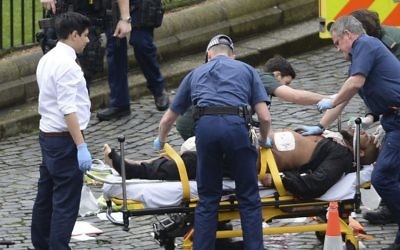 In this March 22, 2017 photo, Khalid Masood is treated by emergency services after a fatal attack outside the Houses of Parliament, London. British Police named Masood on March 23, 2017, as the terrorist who carried out the attack. (Stefan Rousseau/PA via AP).