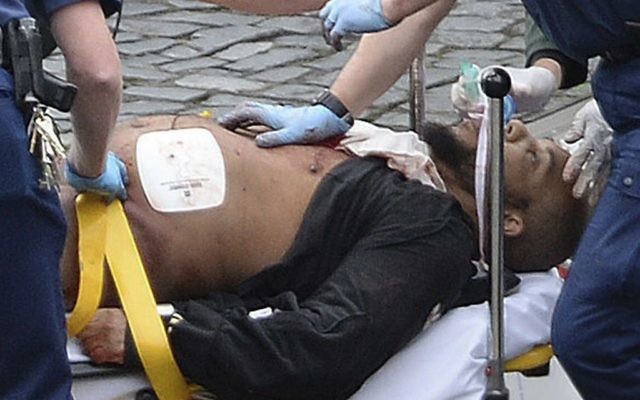 In this March 22, 2017 file photo, the attacker Khalid Masood is treated by emergency services outside the Houses of Parliament London. (Stefan Rousseau/PA via AP)