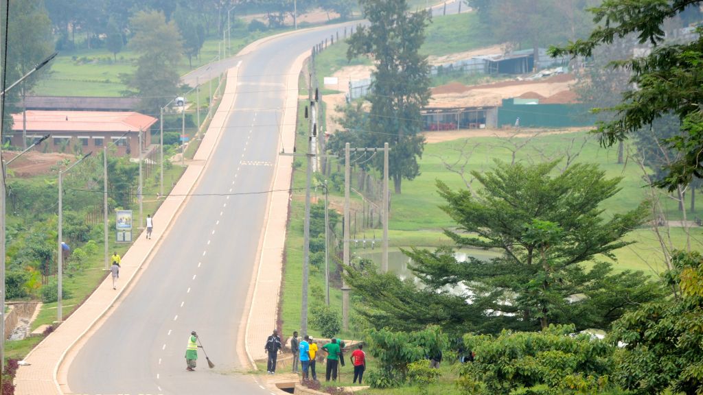 An empty street in the Rwandan capital of Kigali on February 25, 2017, as a woman sweeps during Umuganda community service time. (Melanie Lidman/Times of Israel)