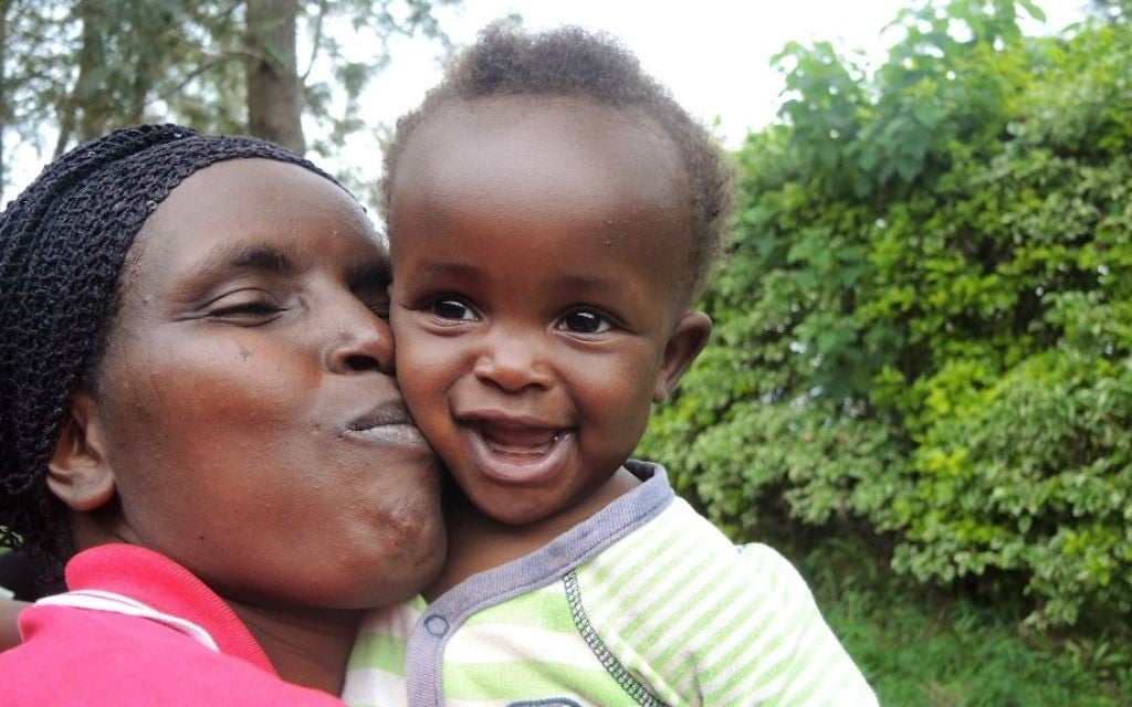 A woman goofs around with her neighbor's baby during the Umuganda community meeting in Kigali, Rwanda on February 25, 2017. (Melanie Lidman/Times of Israel) A woman goofs around with her neighbor's baby during the Umuganda community meeting in Kigali, Rwanda on February 25, 2017. (Melanie Lidman/Times of Israel)