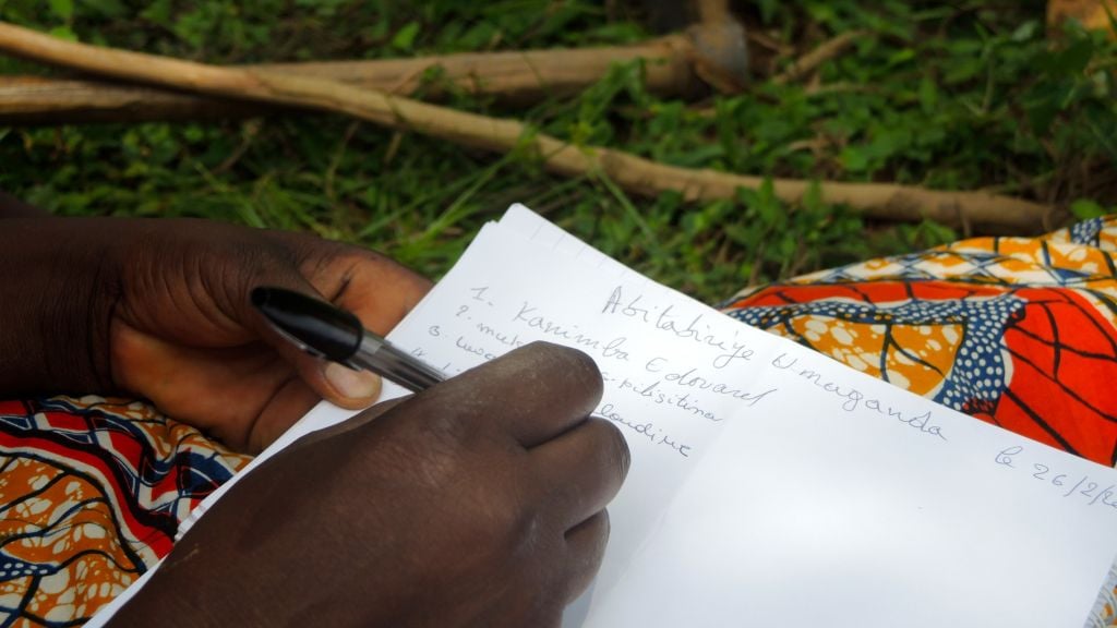 Residents of Kimana Village, a middle-class neighborhood in Kigali, Rwanda, sign in on the attendance sheet at the Umuganda community meeting on February 25, 2017. (Melanie Lidman/Times of Israel)