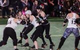 Dara Fineman, left, gets involved in some Gotham Girls Roller Derby League action in a match in Brooklyn, N.Y., March 19, 2017. (Sean Hale/JTA)