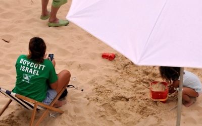 Israel Boycott activists protest at the site where the city of Paris set up a Tel Aviv-style beach on the banks of the Seine River on August 13, 2015. (Serge Attal/Flash90)