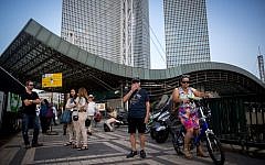 People wait for the bus near Hashalom train station by the Azrieli towers in Tel Aviv, September 22, 2016. (Miriam Alster/Flash90)