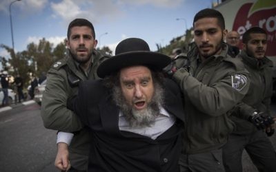 Ultra-Orthodox Jewish men protest against the arrest of a Jewish seminary student who failed to comply with a recruitment order, at the entrance to Jerusalem, on March 20, 2017. (Yonatan Sindel/Flash90)