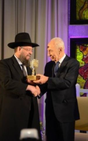 Rabbi Yeshayahu Heber receives an award from then-president Shimon Peres in 2014. (Matnat Chaim/Facebook)