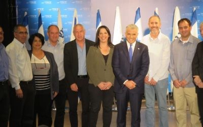 Yesh Atid chairman Yair Lapid (4th from right) surrounded by MKs from his party and seven regional council heads who have joined Yesh Atid, March 7, 2017. (Courtesy)