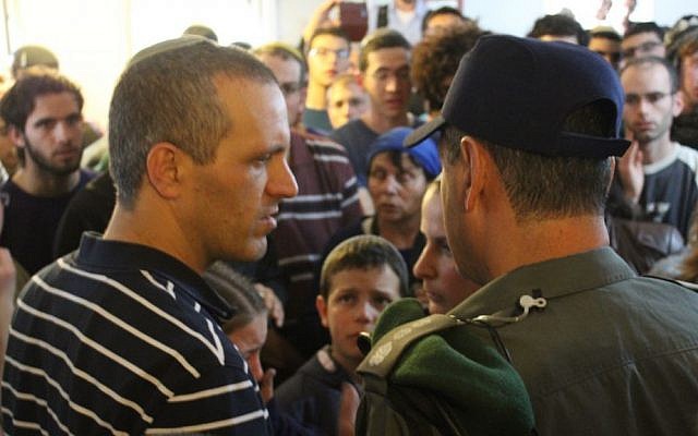 Bini Eldar speaking to a Berder Police officer before his house in the West Bank Ofra settlement was evacuated, February 28, 2017. (Raoul Wootliff/Times of Israel)
