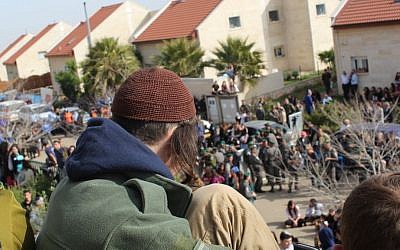 A protester looks down from a rooftop of a building slated to be demolished in the West Bank Ofra settlement, February 28, 2017. (Raoul Wootliff/Times of Israel)