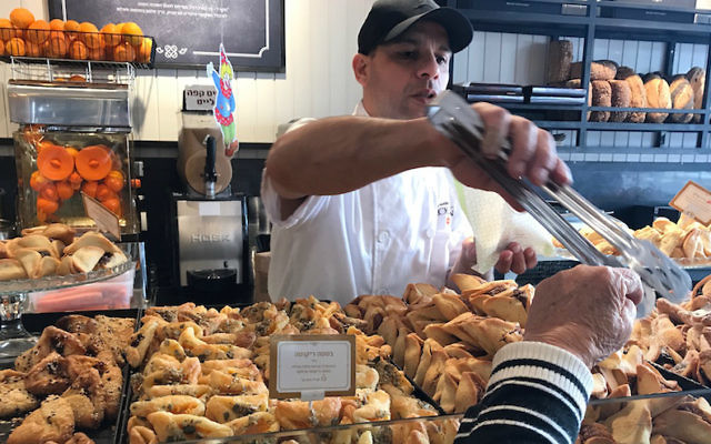 A pastry chef at Roladin serving a customer in Tel Aviv, March 7, 2017. (Andrew Tobin/via JTA)