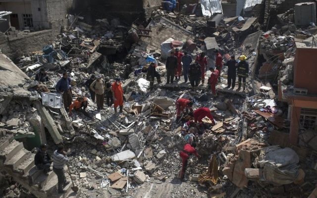 Civil protection rescue team work on the debris of a destroyed house to recover the body of people killed during fights between Iraq security forces and Islamic State on the western side of Mosul, Iraq, Friday, March 24, 2017. (AP Photo/Felipe Dana)
