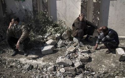 Residents sit next to a destroyed house where several people were killed after it was destroyed during fights between Iraq security forces and Islamic State on the western side of Mosul, Iraq, Friday, March 24, 2017. (AP Photo/Felipe Dana)