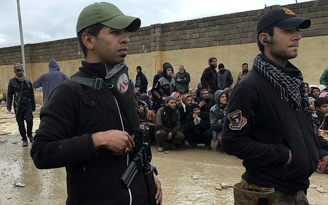 Soldiers stand guard as displaced men who fled their homes due to fighting between Iraqi security forces and Islamic State militants wait for a security check at an Iraqi Army base, west of Mosul, Iraq, Saturday, March 4, 2017. (AP Photo/Mohammed Numan)