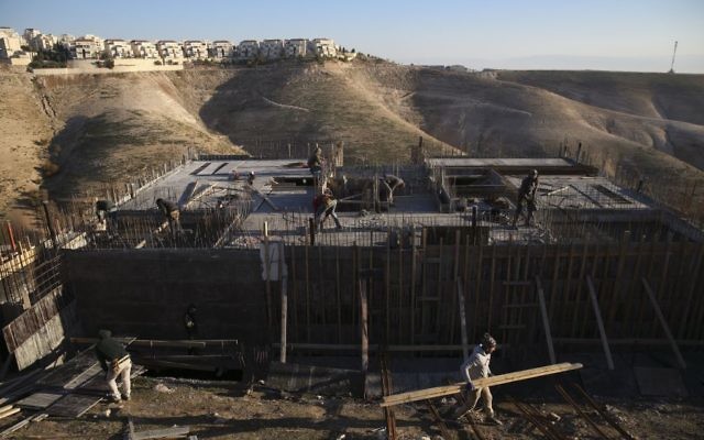 Palestinian laborers work at a construction site in a new housing project in the Israeli settlement of Maale Adumim, near Jerusalem, February 7, 2017. (AP/Oded Balilty, File) Palestinian laborers work at a construction site in a new housing project in the Israeli settlement of Maale Adumim, near Jerusalem, February 7, 2017. (AP/Oded Balilty, File)