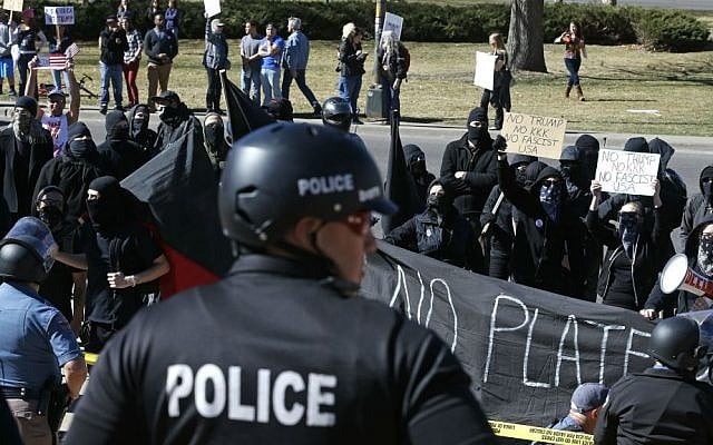 Anti-Trump protesters chant as police separate them from supporters of President Donald Trump gathered nearby during a March 4 Trump rally on the state Capitol steps in Denver, Colorado, Saturday, March 4, 2017. (AP Photo/Brennan Linsley)