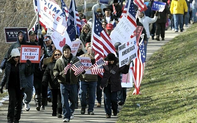 Trump supporters march east on the bike path along Metro Parkway in Clinton Township, Michigan, Saturday, March 4, 2017. (Todd McInturf/Detroit News via AP)