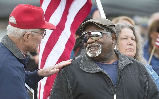Robert Rigert, left, of Naselle, Washington, talks with Glenn Fowler of Belfair, Washington, during a rally for President Donald Trump at Heritage Park in Olympia, Washington, on Saturday, March 4, 2017. (Tony Overman/The Olympian via AP)