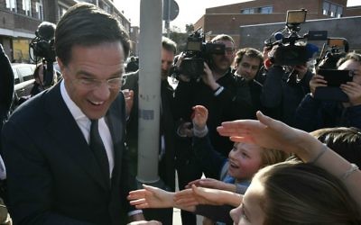 Dutch Prime Minister Mark Rutte shakes hands with children after casting his vote for the Dutch general election in The Hague, Netherlands, Wednesday, March 15, 2017. (AP Photo/Patrick Post)