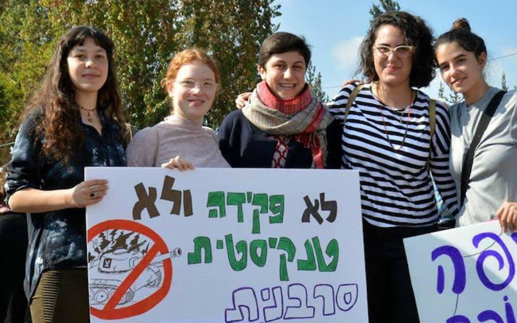 Tamar Alon, second from left, and Tamar Ze'evi, center, protesting against being drafted into the Israeli army. The sign reads, 'Neither clerks nor tank drivers, we are refusers and feminists.' (Courtesy of Mesarvot) Tamar Alon, second from left, and Tamar Ze'evi, center, protesting against being drafted into the Israeli army. The sign reads, 'Neither clerks nor tank drivers, we are refusers and feminists.' (Courtesy of Mesarvot)