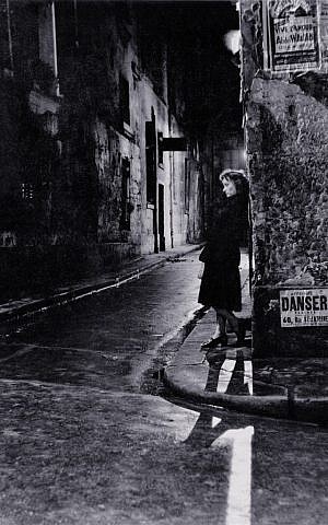 A woman in Paris at night, a photo by Adolfo Kaminsky. (Courtesy)