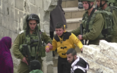 A Palestinian boy being led through the streets of Hebron, whom the army says is suspected of throwing a firebomb at a Jewish settlement, on March 21, 2017. (Screen capture: B'Tselem)