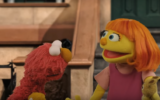 New Sesame Street character Julia (L) with longtime figure of TV show Elmo. (Screen capture: YouTube)