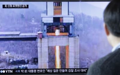 A man watches a TV news program showing an image that North Korea's Rodong Sinmun newspaper reports of a ground test of a new type of high-thrust rocket engine at Seoul Railway station in Seoul, South Korea, Sunday, March 19, 2017. (AP Photo/Ahn Young-joon)