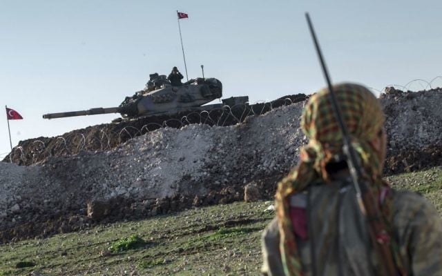 In this February 22, 2015, file photo, a Syrian Kurdish militia member of the YPG patrols near a Turkish army tank in Esme village in Aleppo province, Syria. (AP Photo/Mursel Coban, Depo Photos, File)