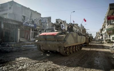In this February 22, 2015, file photo, Turkish military vehicles and tanks drive in the Syrian town of Ayn al-Arab, also known as Kobani, Syria. (AP Photo/Mursel Coban, Depo Photos, File)