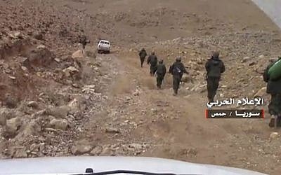 In this March 1, 2017 frame grab from video provided by the government-controlled Syrian Central Military Media, Syrian forces take up positions during fighting between Government forces and Islamic State group militants in the ancient city of Palmyra, near Homs, Syria. (Syrian Central Military Media, via AP)