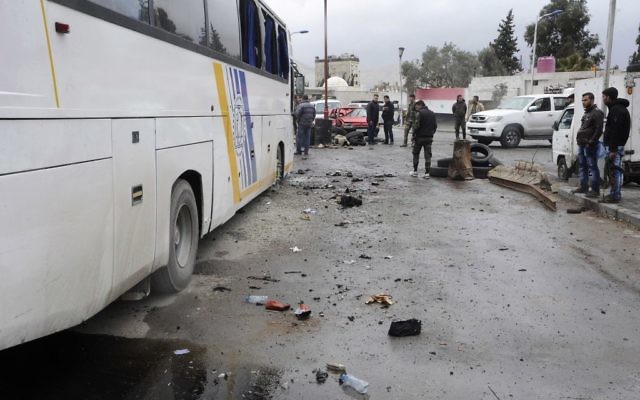People inspect damage in a parking lot at the site of an attack by twin explosions in Damascus, Syria, Saturday, March 11, 2017 (SANA via AP) People inspect damage in a parking lot at the site of an attack by twin explosions in Damascus, Syria, Saturday, March 11, 2017 (SANA via AP)