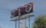A new billboard created by an artist depicting President Donald Trump with swastika-like imagery for dollar signs in downtown Phoenix, Arizona on March 18, 2017. (Screen capture/Reuters)